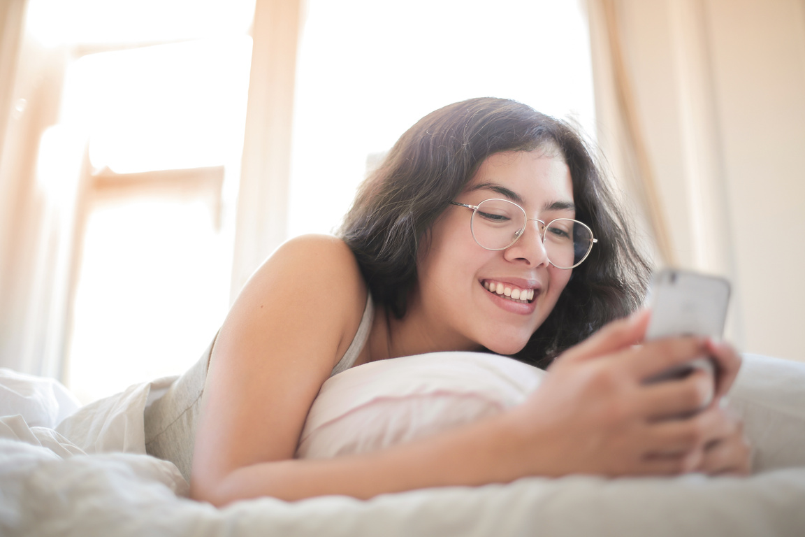 Woman in White Tank Top Lying on Bed